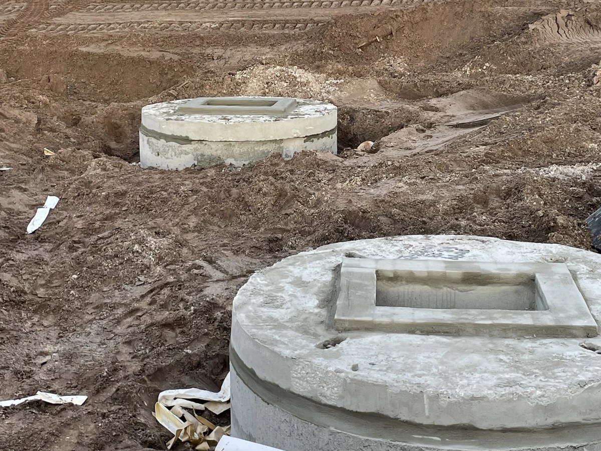 Newly installed precast concrete storm-water inlets sitting on prepped ground — North Port, Florida